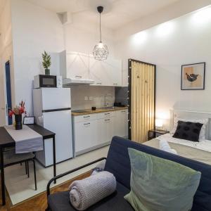 ein Wohnzimmer mit einem Sofa und einer Küche in der Unterkunft STUDIO MG in Zagreb