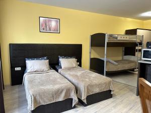 a room with two beds and a bunk bed at Apartments & Rooms Royal Plaza in Borovets
