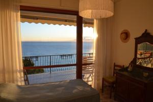 a bedroom with a view of the ocean from a balcony at Rocce di Capo Mimosa - Cervo in Cervo