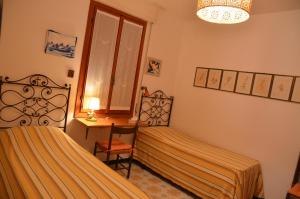 a bedroom with two beds and a chair and a desk at Rocce di Capo Mimosa - Cervo in Cervo