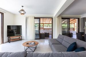 a living room with a couch and a table at Villa Chnaris - Private Pool and Sauna in Perama