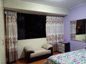 1 dormitorio con 1 cama, 1 silla y ventanas en Apartamento frente a hermoso Parque, en Lima