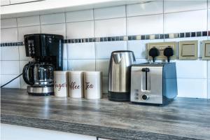a kitchen counter with a coffeemaker and a coffee maker at Eric Wilkins Apartments in Kampala