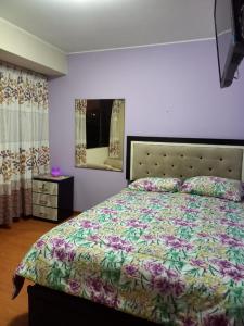 1 dormitorio con 1 cama grande y espejo en Apartamento frente a hermoso Parque, en Lima