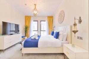 ein Schlafzimmer mit einem großen Bett und einem TV in der Unterkunft Ultra Luxury Downtown - Full Burj Khalifa View - 5 Min Walk To Dubai Mall! in Dubai