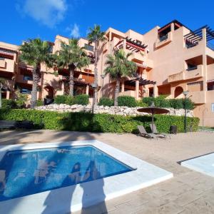a resort with a swimming pool in front of a building at Luxury large 2 bedroom Apartment short walk to Villamartin Plaza in Villamartin