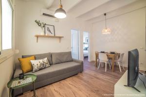 uma sala de estar com um sofá e uma mesa em Poblenou 3bd 5 min to the Beach em Barcelona