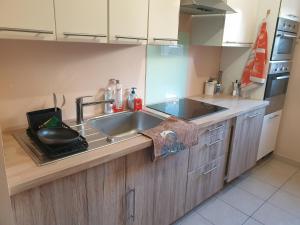 a kitchen with a sink and a counter top at Spacieux et calme, style parisien, toutes commodités, idéal pour un séjour authentique in Saint-Denis +18 photos