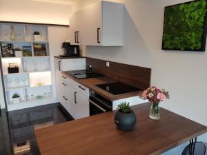 a kitchen with white cabinets and a wooden table at Black&White Luxus Appartement - Wilbergé Chalets in Gotteszell