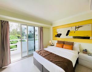 ein Schlafzimmer mit einem großen Bett und einem großen Fenster in der Unterkunft Bellagio Pets Friendly Resort in Hongkong