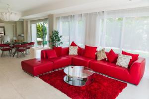 un sofá rojo con almohadas rojas en la sala de estar. en Luxury Private Villas with Pool, Beach, BBQ - FREE GolfCart in May, en Punta Cana