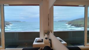a room with a view of the ocean from a balcony at Apartamento Sisargas in Malpica