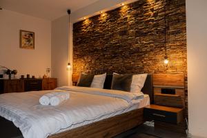 Schlafzimmer mit Ziegelwand und großem Bett in der Unterkunft JANINE GARDEN in Braşov