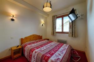 een slaapkamer met een bed en een tv aan de muur bij B406- Appartement 2 pieces cabine 6 personnes in Orcières