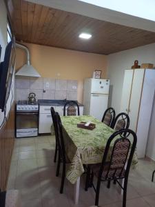 cocina con mesa, sillas y nevera en Turismo en san Rafael Mendoza en San Rafael