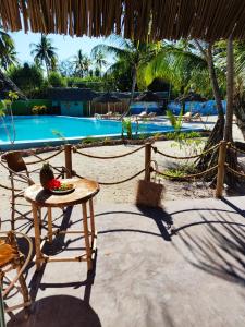 a table with a bowl of fruit on it next to a pool at Princess of Zanzibar in Michamvi