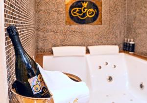 a bottle of champagne in a bucket next to a bath tub at EGO' Boutique Hotel - The Silk Road in Venice
