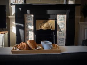 a tray of croissants and a plate of croissants on a table at The Beeches - Chatsworth Apartment No 1 - Sleeps 4 in Baslow