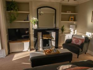 uma sala de estar com lareira e televisão em The Beeches - Chatsworth Apartment No 1 - Sleeps 4 em Baslow