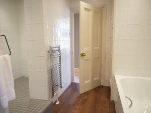 ein weißes Badezimmer mit einer Badewanne und einem Waschbecken in der Unterkunft The Beeches - Chatsworth Apartment No 1 - Sleeps 4 in Baslow