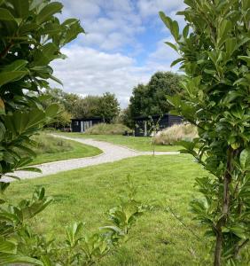 a gravel road through a park with green grass at Meadow View - Bottom Cabin in Foolow