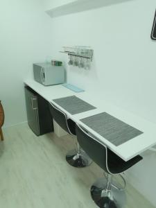 a kitchen with a white counter top and a microwave at Habitación con entrada independiente in Vigo