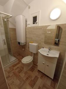 uma casa de banho com um WC, um lavatório e um chuveiro em Kata Apartman em Sátoraljaújhely