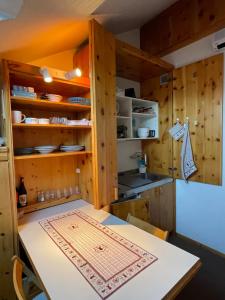 uma cozinha com armários de madeira e uma mesa em Deer Attic em Pila