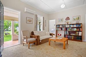 a living room with a couch and a table at Whare Nui on Rennie - Thames Holiday Home in Thames