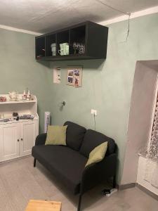 Piccolo paradiso في Prata: غرفة معيشة مع أريكة سوداء في غرفة