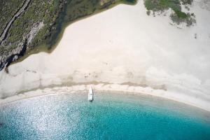 a sailboat in the water next to a beach at Onar Andros in Achla