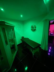 une salle verte avec une table et un miroir dans l'établissement Au nid d'amour, à Bellencombre