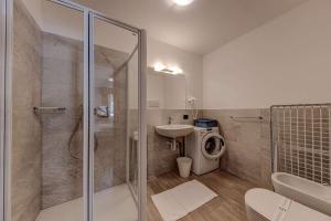 a bathroom with a shower and a toilet and a sink at Appartamenti Stefan in Campitello di Fassa