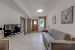 a living room with a couch and a flat screen tv at Appartamenti Stefan in Campitello di Fassa