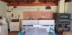 Il comprend une cuisine équipée d'une table, de chaises et d'une cuisinière. dans l'établissement Bellona 319, à Comiso