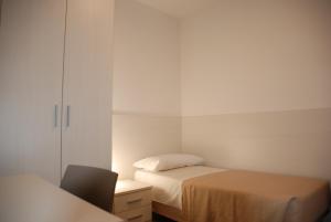 a small bedroom with two beds and a cabinet at Hotel Lugano Torretta in Marghera