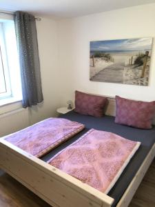a bedroom with two beds with purple pillows at Villa Bella Vista - Meerblick 1 in Sassnitz