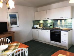 ザスニッツにあるVilla Bella Vista - Meerblick 6のキッチン(白いキャビネット、テーブル付)、ダイニングルーム