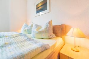 1 dormitorio con 1 cama con almohadas y lámpara en Villa Bella Vista - Meerblick 4, en Sassnitz