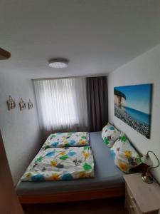 um pequeno quarto com uma cama com uma colcha e almofadas em Villa Bella Vista - Meerblick 2 em Sassnitz