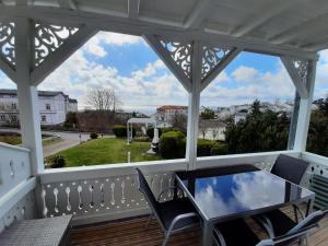 um alpendre com uma mesa de vidro e cadeiras em Villa Bella Vista - Meerblick 2 em Sassnitz