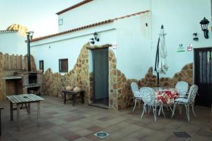 une terrasse avec une table et des chaises devant un bâtiment dans l'établissement Casa Cueva Picoesquina, à Guadix