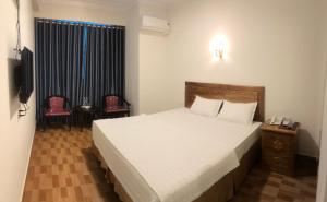 a bedroom with a large bed and a television at Trường Thịnh Hotel in Vinh