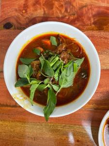 a bowl of soup on a wooden table at Thuận Phát Hotel in Soc Trang