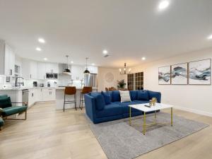 a living room with a blue couch and a kitchen at @ Marbella Lane – Contemporary Sophisticated Home in Sunnyvale