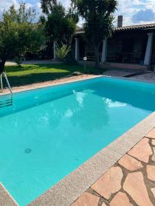uma piscina com água azul em frente a uma casa em La casa di Simona em Telti