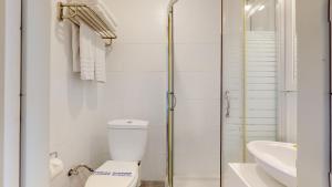 a white bathroom with a toilet and a sink at Acrotel Elea Beach in Elia