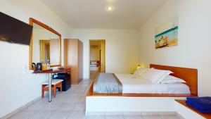 a hotel room with a bed and a desk at Acrotel Elea Beach in Elia
