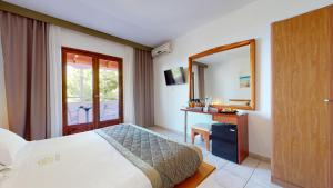 a hotel room with a bed and a mirror at Acrotel Elea Beach in Elia