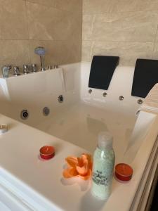 a bath tub with a bottle of soap and an orange flower on it at AIR FERVENZA in Dumbría